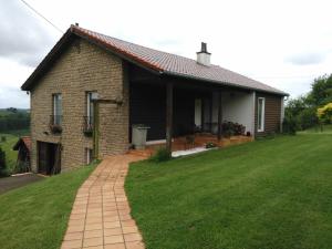 Gite des 3 bouleaux في Robelmont: منزل من الطوب مع حديقة خضراء أمامه