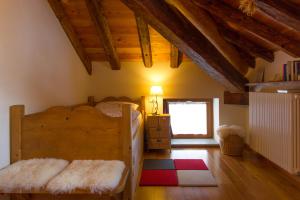 a bedroom with a wooden bed and a window at Tre Alberi Liberi in Alagna Valsesia