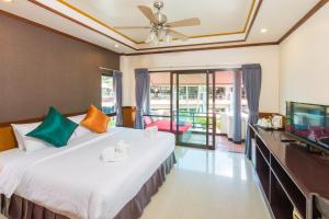 a bedroom with a large bed and a flat screen tv at Sunrise Resort- Koh Phangan - SHA Extra Plus in Haad Rin +37 photos