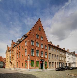 ein großes Backsteingebäude mit dreieckigem Dach auf einer Straße in der Unterkunft Hotel Jacobs in Brügge