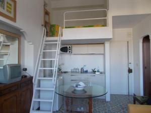 a kitchen with a ladder and a glass table in a room at Casa Montagnese in Anacapri