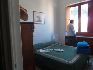 a man standing in a room looking out the window at Casa Montagnese in Anacapri