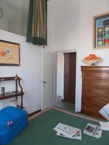 アナカプリにあるCasa Montagneseのベッドとドレッサー付きの部屋、緑の床の部屋