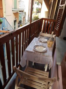 - Balcón con mesa, sillas y vasos en Appartamento Speranza en Pisogne