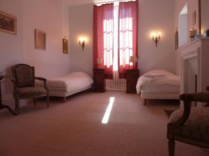 a living room with two beds and a window at Hôtes de Montboulan in Salbris