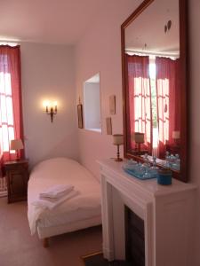サルブリにあるHôtes de Montboulanのベッドルーム(鏡、ベッド、シンク付)