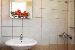 baño con lavabo, espejo y ventana en Eleana Studios, en Lefkada