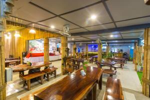 a restaurant with many wooden tables and benches at Sunrise Resort- Koh Phangan - SHA Extra Plus in Haad Rin