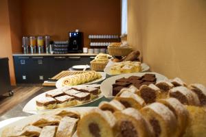 a table filled with different types of cakes and pastries at Clarion Congress Hotel Olomouc in Olomouc