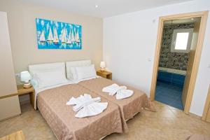 A bed or beds in a room at Villa Fantasia- Less than 5-Min Walk to Kalivaki Beach