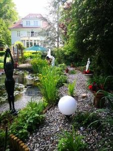 a garden with a pond and a statue and a ball at Pension Celia in Wismar