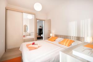 1 dormitorio blanco con 1 cama blanca grande con almohadas de color naranja en STAR WARS - Apartments Pina en Cavtat