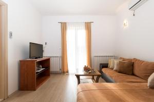 Televízia a/alebo spoločenská miestnosť v ubytovaní Apartments Pina
