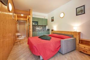 una camera con un letto con una coperta rossa di Appartamenti Carlotta ad Arabba