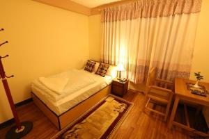 a small bedroom with a bed and a table at Aarya Chaitya Inn in Kathmandu