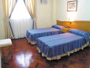 Säng eller sängar i ett rum på Alcor Hotel