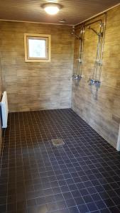 a bathroom with a shower and a tiled floor at Saaristohotelli Vaihela in Velkua