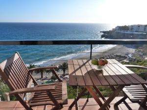 a table and chairs on a balcony with the ocean at El Salon, Nerja BLUEWATER VILLAS in Nerja