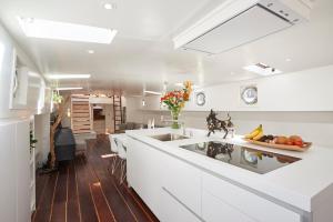 Una cocina con gabinetes blancos y un fregadero grande. en Luxurious 110m² 3br Houseboat in Amsterdam Centre!, en Ámsterdam
