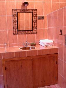 ein Bad mit einem Waschbecken und einem Spiegel in der Unterkunft Gite Elkhorbat in Tinejdad
