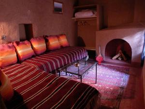 a living room with two couches and a fireplace at Gite Elkhorbat in Tinejdad