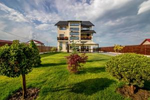 a house with a green yard with trees at Riana in Adjud