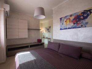 una camera da letto con un letto e un dipinto sul muro di Castiglione Residence a Foggia