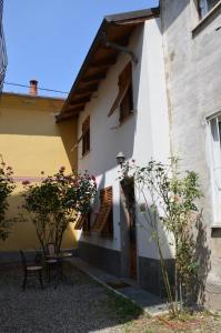 un edificio blanco y amarillo con mesa y sillas en La Casetta, en Stazzano