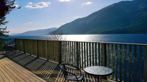 a balcony with a table and chairs and a view of a lake at Letterfinlay Lodge House in Letterfinlay
