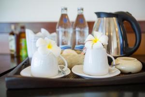two white mugs with flowers on them on a tray at Sunrise Resort- Koh Phangan - SHA Extra Plus in Haad Rin