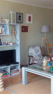 a living room with a tv and a table and a chair at Bayview Heights Gem in Simonʼs Town