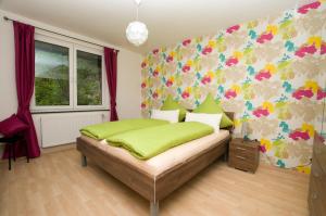 コッヘムにあるHaus Danaの花の壁のベッドルーム1室(緑のベッド1台付)
