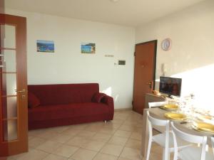 a living room with a red couch and a table at Castello 9 in Isola del Giglio