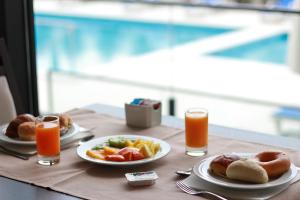 a table with plates of food and two glasses of orange juice at Hotel Monte Lírio in Espinho