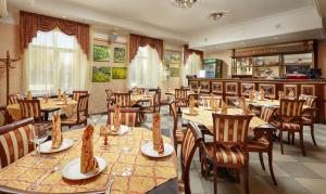 a restaurant with tables and chairs with food on them at Rublev Hotel in Gorodets