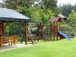 a park with a playground with a slide and benches at Agroturystyka Pod Brzozami in Susiec