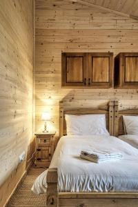 a bedroom with a bed in a wooden wall at Belianska Chata in Ždiar