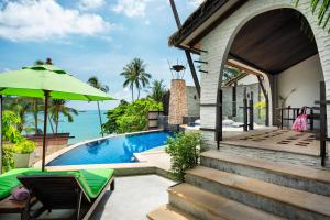 a house with a swimming pool and an umbrella at Panviman Resort Koh Phangan - SHA Extra Plus in Thong Nai Pan Noi