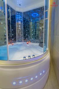 沙魯拉的住宿－Sharurah Plaza Hotel，一间带玻璃窗户和浴缸的浴室