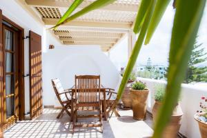 a patio with two chairs and a table on a balcony at Apartment Kalypso in Agia Anna Naxos