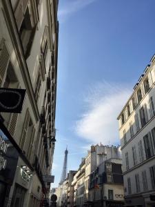 une rue urbaine avec des bâtiments et la tour eiffel dans l'établissement Appartement Saint-Dominique 7 eme, à Paris