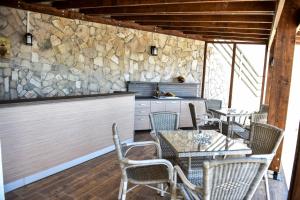 a kitchen with tables and chairs and a stone wall at Villa Premier in Ulcinj