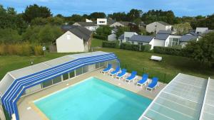 een uitzicht op een zwembad met stoelen en een huis bij VVF Piriac-sur-Mer Bretagne Sud in Piriac-sur-Mer