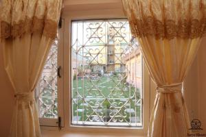 a window with curtains and a view of a yard at Aarya Chaitya Inn in Kathmandu