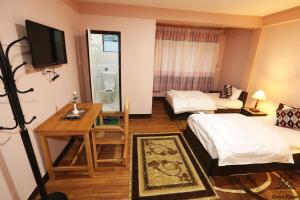 a hotel room with two beds and a television at Aarya Chaitya Inn in Kathmandu