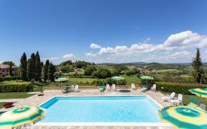 a swimming pool with chairs and umbrellas in a yard at Monti 1824 in Casole dʼElsa