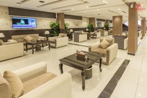 a lobby with couches and tables and a tv at Sharurah Plaza Hotel in Sharurah