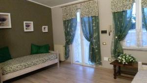 a bedroom with a bed and two windows with curtains at La Fontanella in Quartu SantʼElena