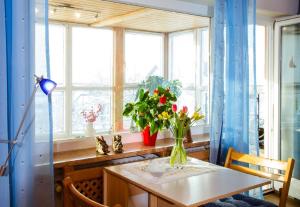 uma sala de jantar com uma mesa com flores num vaso em Ferienwohnung "Gaby" em Freyung