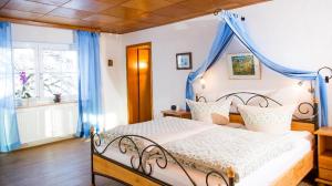 een slaapkamer met een bed met een blauwe baldakijn bij Ferienwohnung "Gaby" in Freyung
